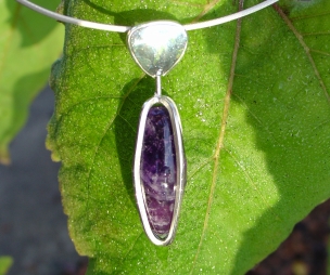 Sterling silver caged Amethyst on a neck wire.